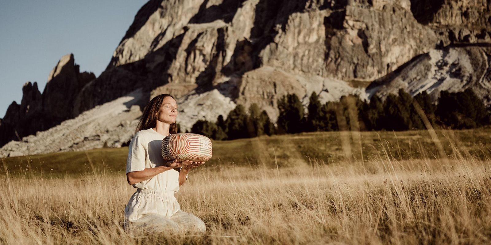Moments of calm in the South Tyrol Dolomites with a woman and a handcrafted yoga cushion