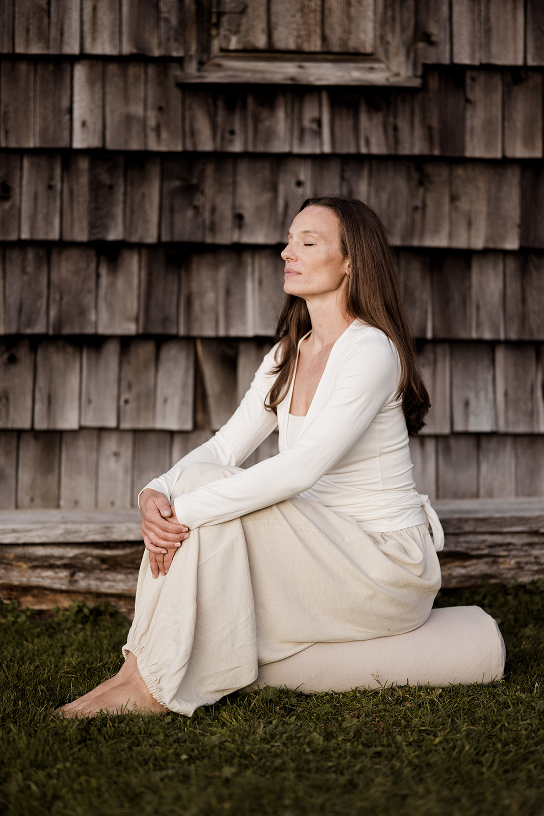 Donna su un bolster yoga artigianale di Manna Yoga Alto Adige
